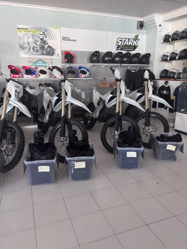 Las Stark Varg EX en el local, con los cascos en las estanterías y una caja de material preparada con el nombre de cada persona